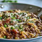 Savory Comforting Ground Beef Orzo Dinner featuring tender orzo, sweet bell peppers, and peas in a rich tomato beef broth.
