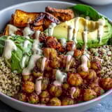 Overhead view of the Roasted Chickpea Power Bowl featuring quinoa, avocado slices, and caramelized sweet potatoes on a rustic table.