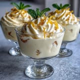 Refreshing lemon mousse cups topped with fresh berries and mint, paired with homemade buttery shortbread for a delightful dessert.  