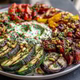 Vibrant Mediterranean-style veggie platter with smoky grilled vegetables and smooth homemade hummus, perfect for sharing at gatherings.  