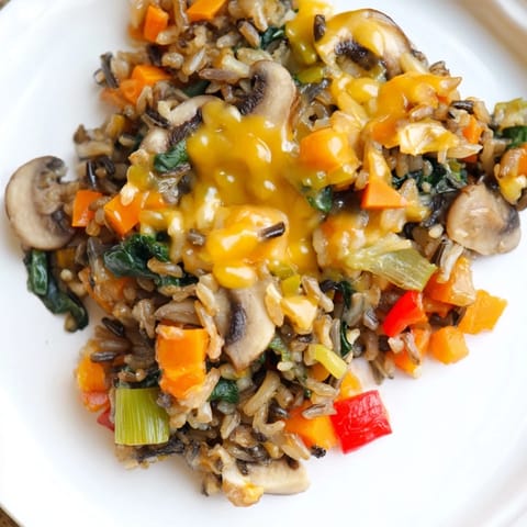 Warm wild rice casserole, featuring hearty mushrooms and cheese, perfect for a cozy dinner.