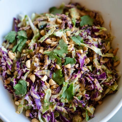 A close-up of Crunchy Thai Peanut Salad, featuring colorful vegetables and a glossy peanut-lime dressing, perfect for a refreshing, vegan side dish.