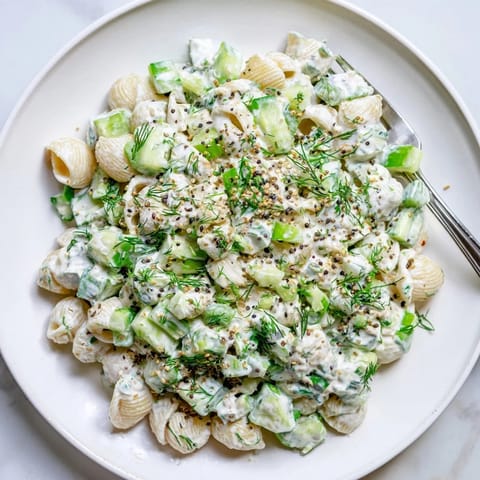 A chilled bowl of Cucumber Crunch Pasta Salad, garnished with everything bagel seasoning, makes a refreshing side for summer barbecues.  