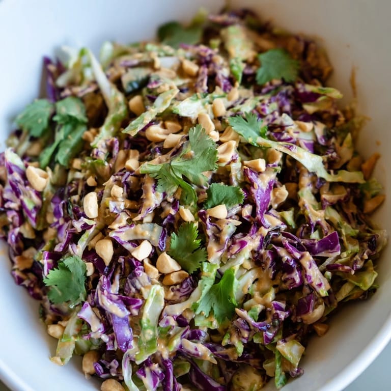 A close-up of Crunchy Thai Peanut Salad, featuring colorful vegetables and a glossy peanut-lime dressing, perfect for a refreshing, vegan side dish.