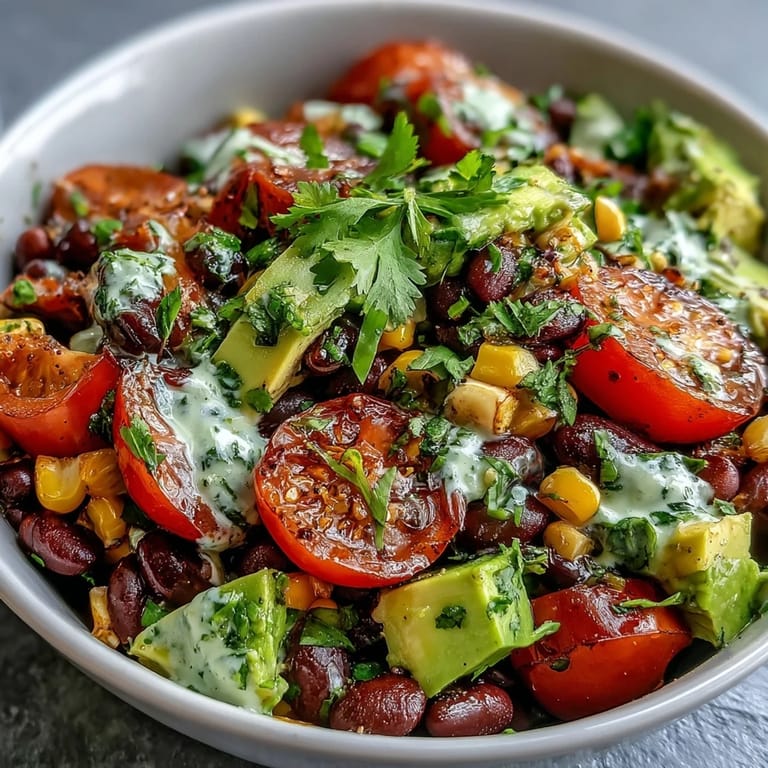 A colorful Black Bean and Veggie Bowl topped with creamy avocado slices, fresh cilantro, and a zesty lime dressing.