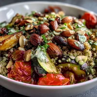 A vibrant Veggie and Quinoa Power Bowl with roasted vegetables and crunchy almonds, drizzled with zesty lemon vinaigrette.