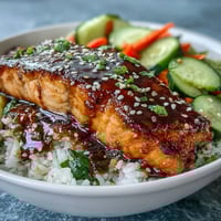 A colorful teriyaki salmon bowl with glazed fillets, jasmine rice, and crisp vegetables, perfect for a quick dinner.